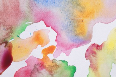 Photo of Abstract colorful watercolor painting on white paper, top view