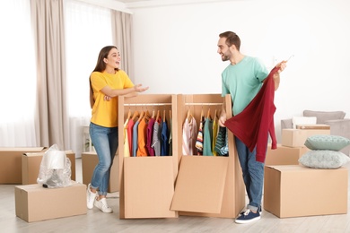 Photo of Young couple near wardrobe boxes at home