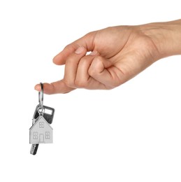 Photo of Woman holding key with metallic keychain in shape of house on white background, closeup