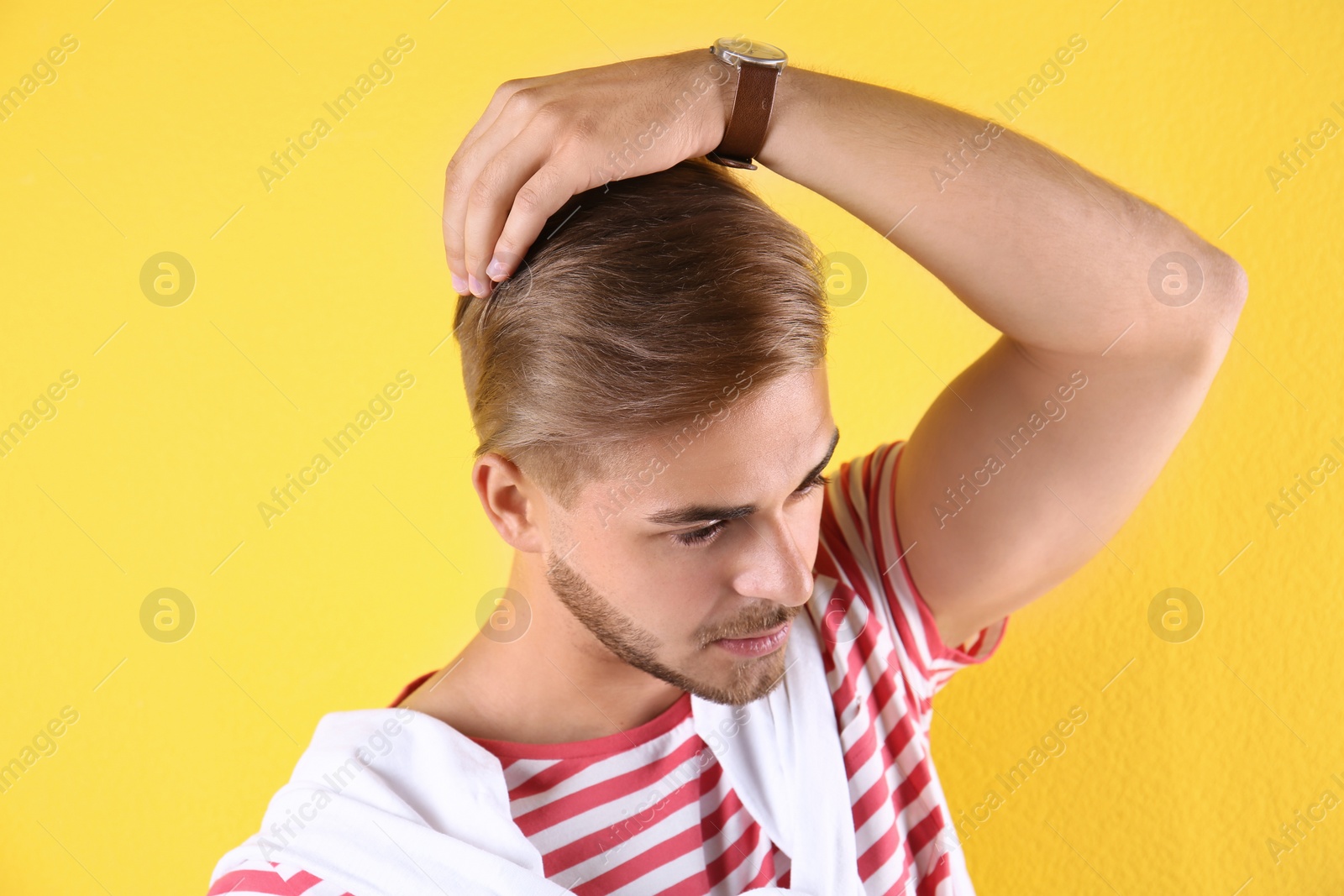 Photo of Young man with trendy hairstyle on color background