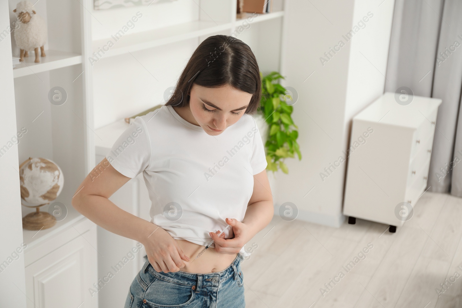 Photo of Diabetes. Woman making insulin injection into her belly at home, space for text