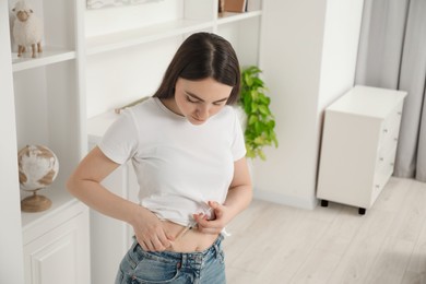 Photo of Diabetes. Woman making insulin injection into her belly at home, space for text