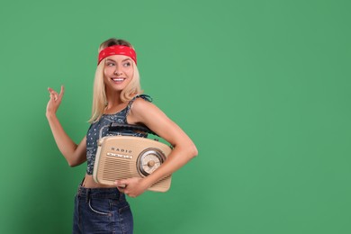 Photo of Happy hippie woman with retro radio receiver on green background. Space for text