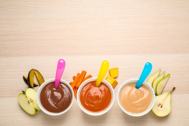 Photo of Healthy baby food and ingredients on wooden table, flat lay. Space for text