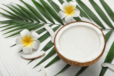 Composition with half of coconut on white wooden background