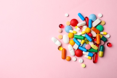 Photo of Pile of different pills on color background, top view. Space for text