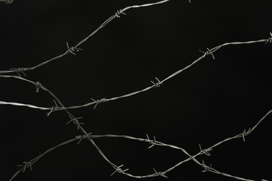 Photo of Shiny metal barbed wire on black background