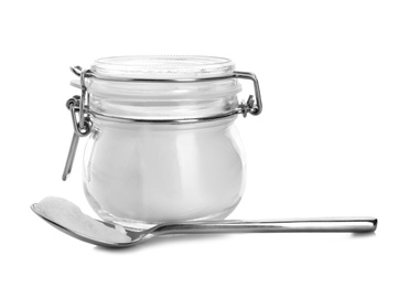 Spoon and jar with baking soda on white background