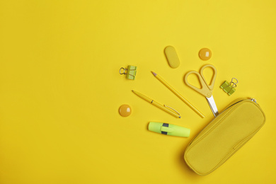 Flat lay composition with pencil box and stationery on yellow background. Space for text