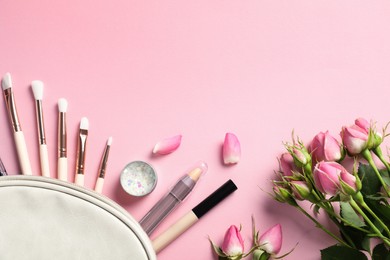Set of makeup products with bag and roses on light pink background, flat lay. Space for text