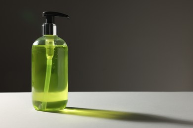 Bottle of liquid soap on grey table. Space for text