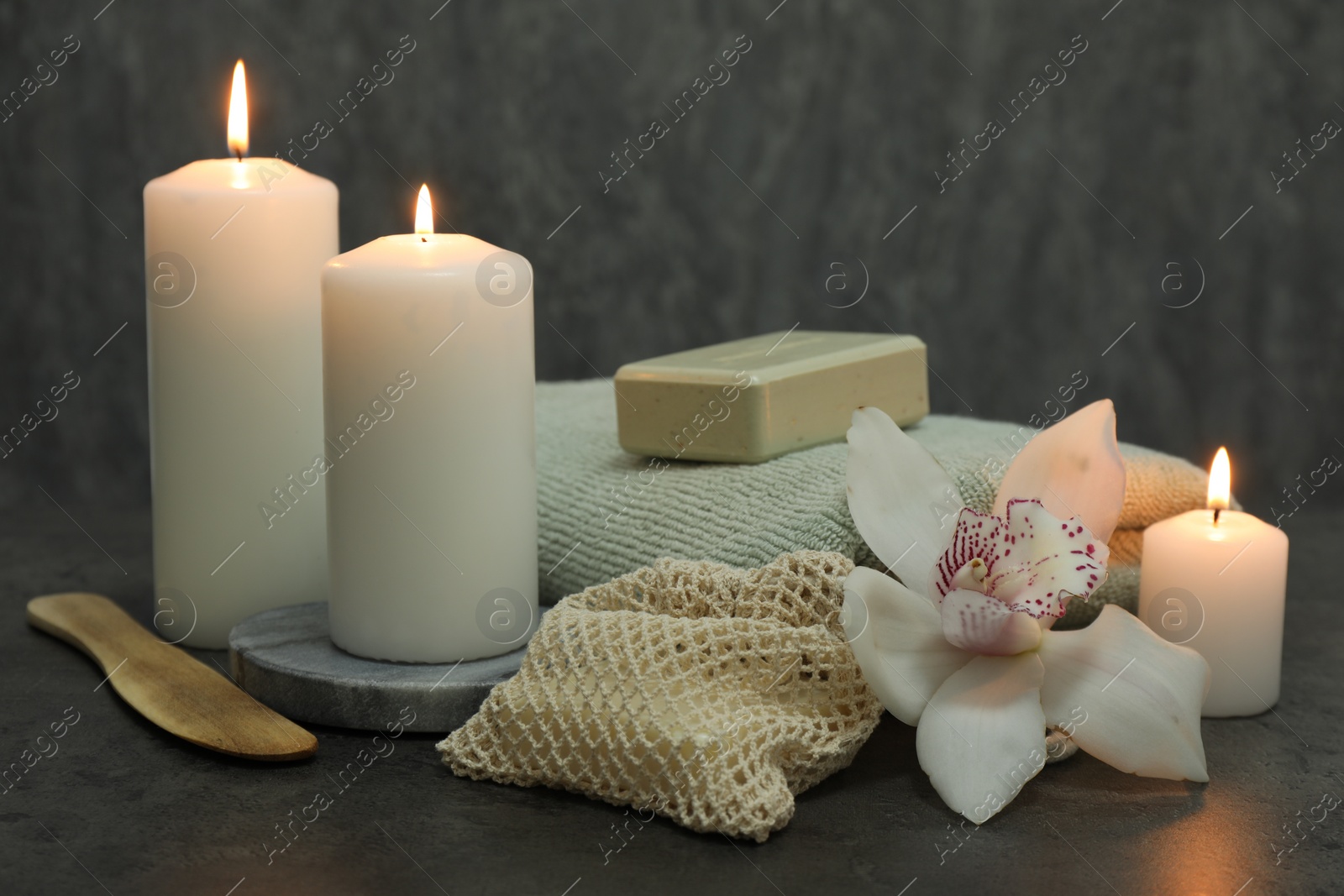 Photo of Composition with different spa products and orchid flower on grey table