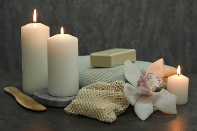 Composition with different spa products and orchid flower on grey table