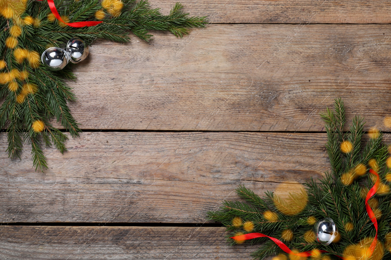 Photo of Christmas greeting card with space for text. Flat lay composition of fir tree branches and festive decor on wooden background