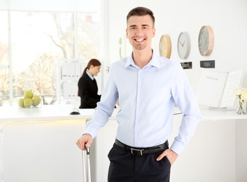 Young man near reception desk in hotel