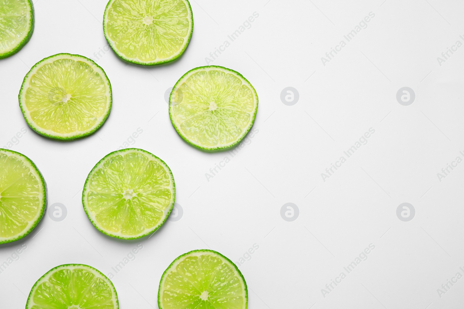 Photo of Juicy fresh lime slices on white background, top view