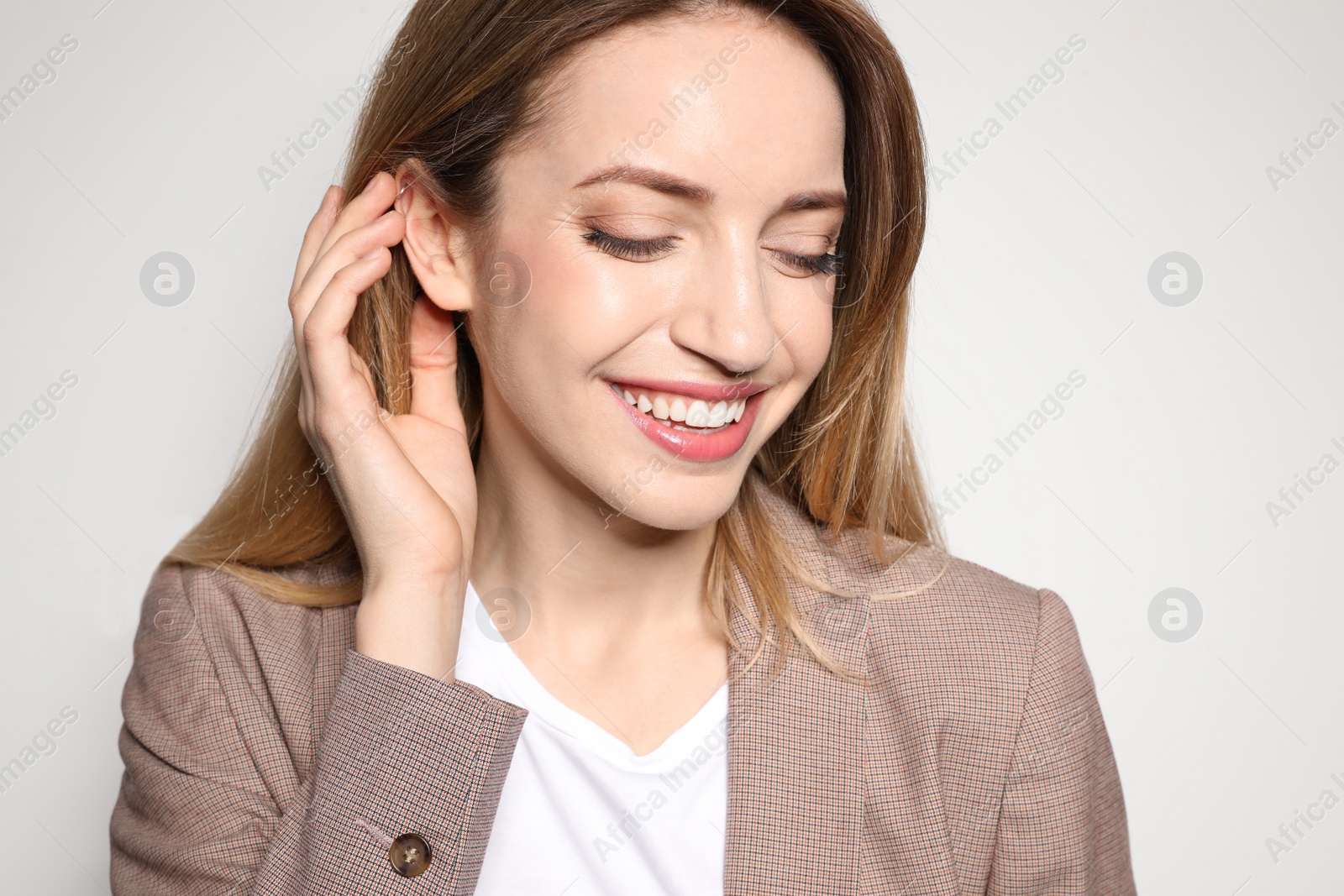 Photo of Portrait of young woman with beautiful face on light background, closeup