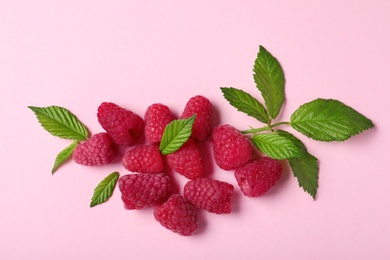 Flat lay composition with delicious ripe raspberries on pink background