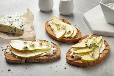 Photo of Delicious bruschettas with pear served on table