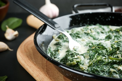 Photo of Tasty spinach dip in frying pan on table, closeup