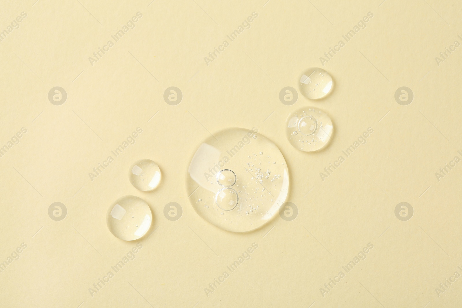 Photo of Samples of cosmetic serum on beige background, flat lay