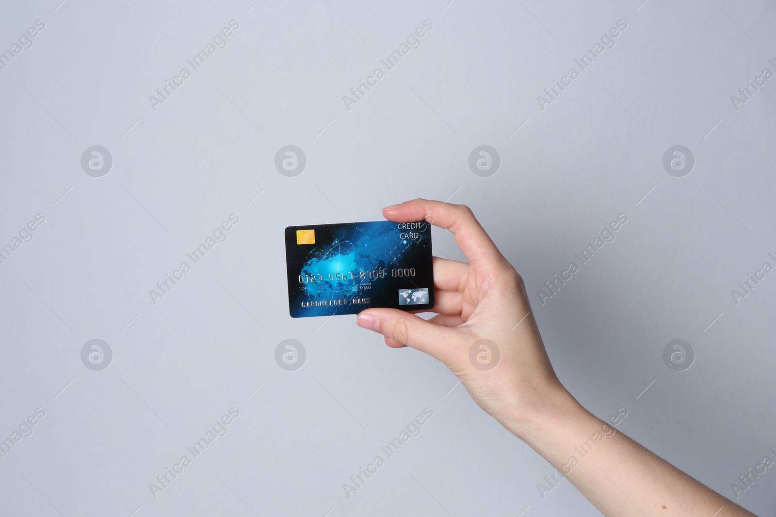 Photo of Woman holding credit card on light grey background, closeup