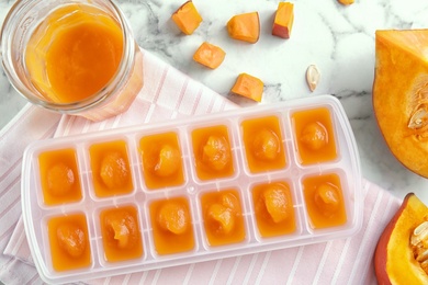 Photo of Flat lay composition with ice cube tray of baby food on marble background