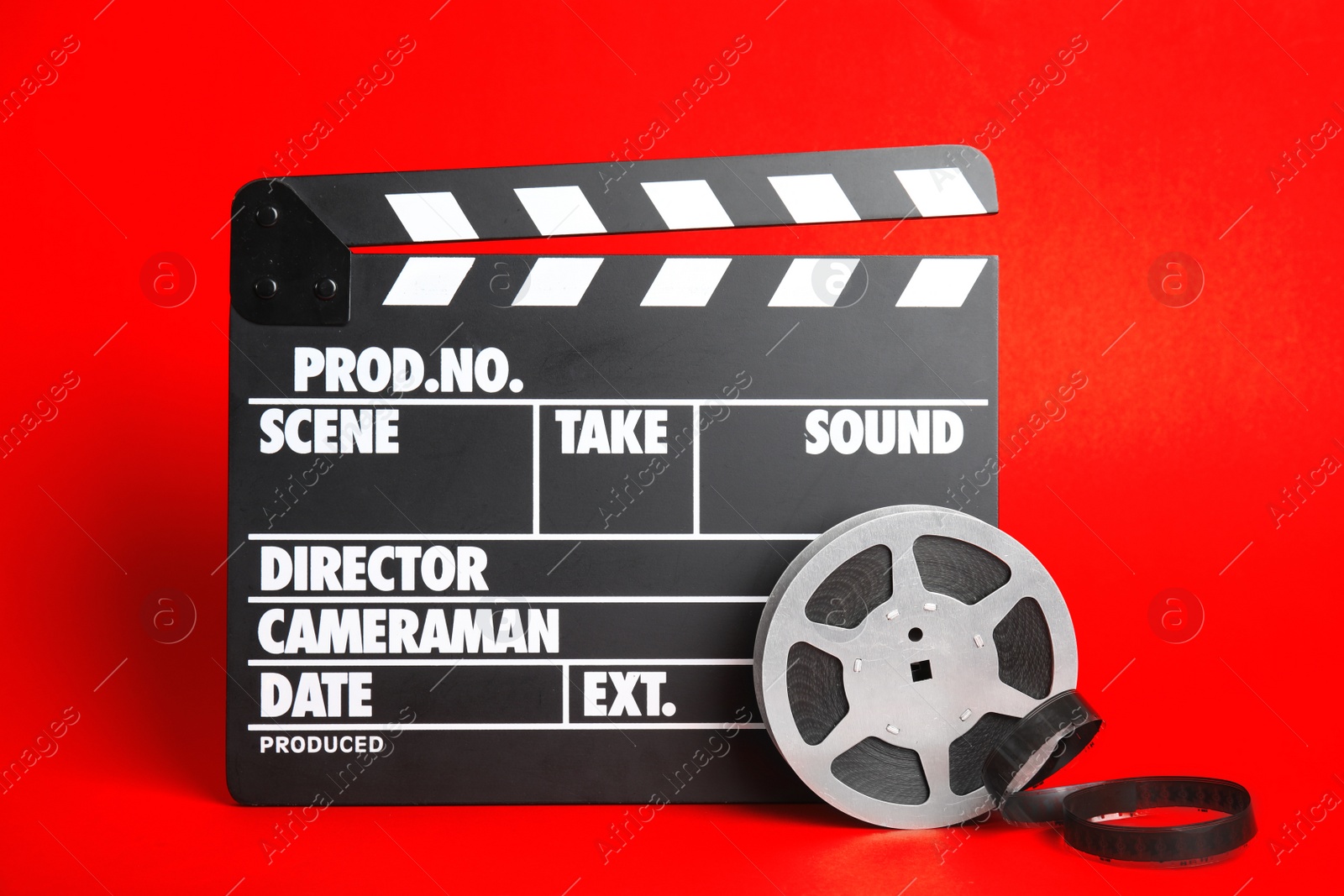 Photo of Clapperboard and reel on color background. Cinema production