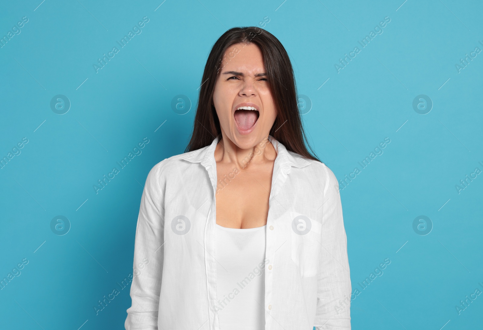 Photo of Aggressive young woman shouting on turquoise background