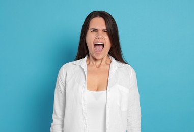 Photo of Aggressive young woman shouting on turquoise background
