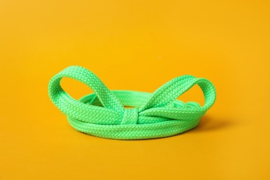 Photo of Green shoe lace on yellow background. Stylish accessory