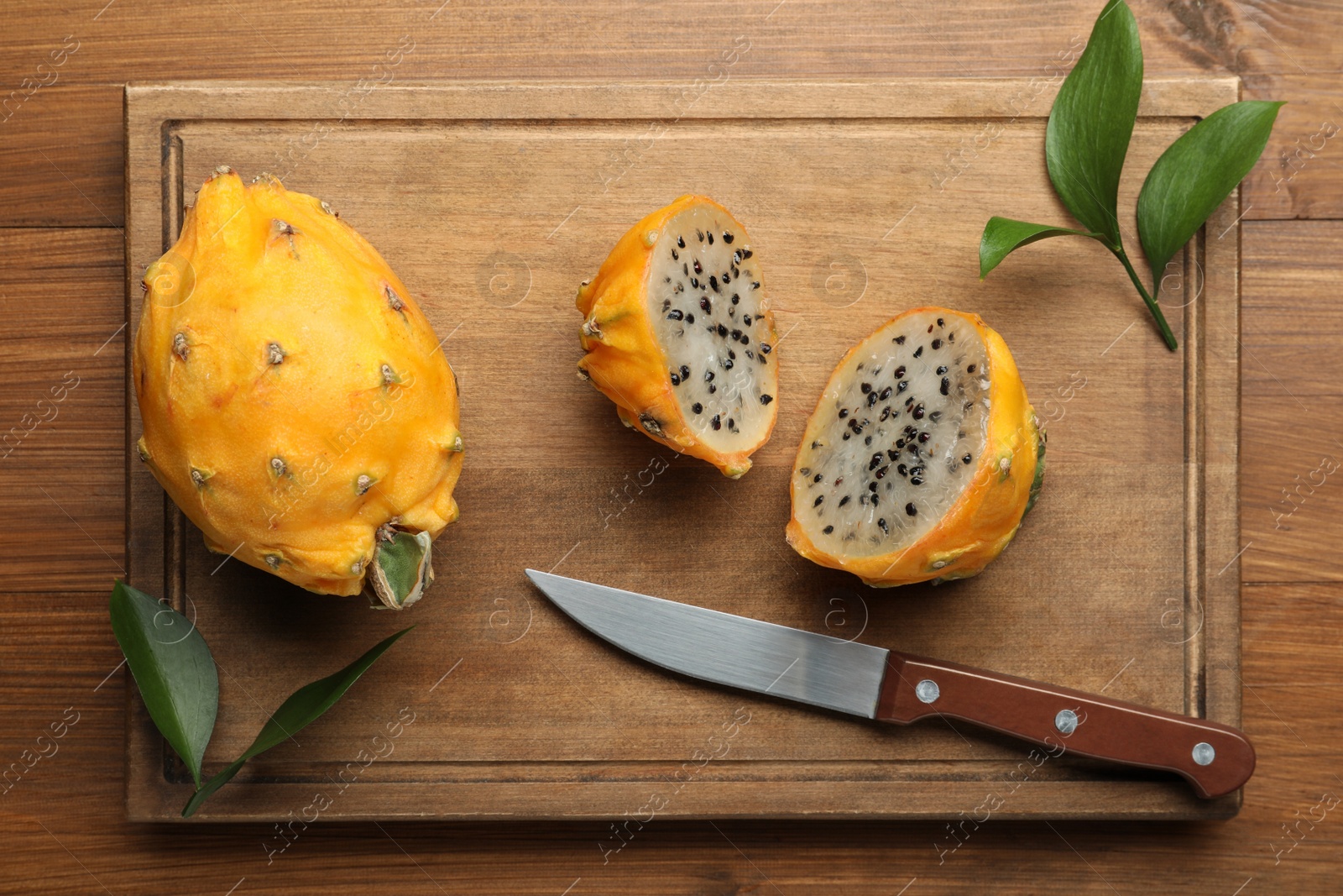 Photo of Delicious cut and whole dragon fruits (pitahaya) on wooden table, top view