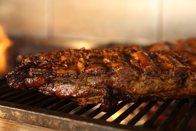 Grilling grate with tasty pork ribs in oven, closeup