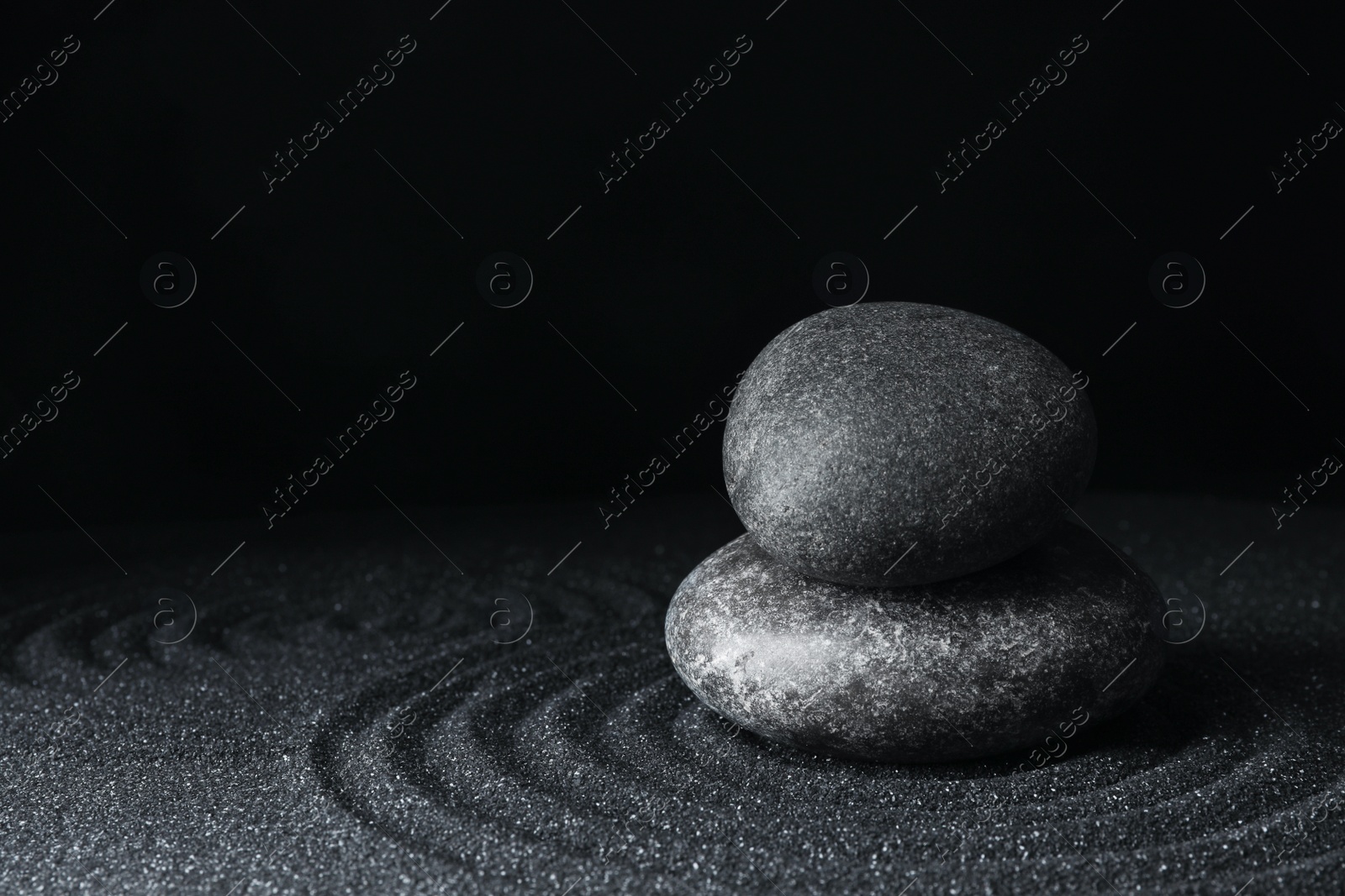 Photo of Spa stones on black sand with beautiful pattern, space for text. Zen and harmony