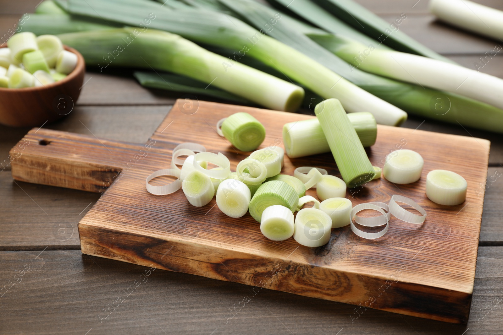 Photo of Fresh raw leek slices on wooden table