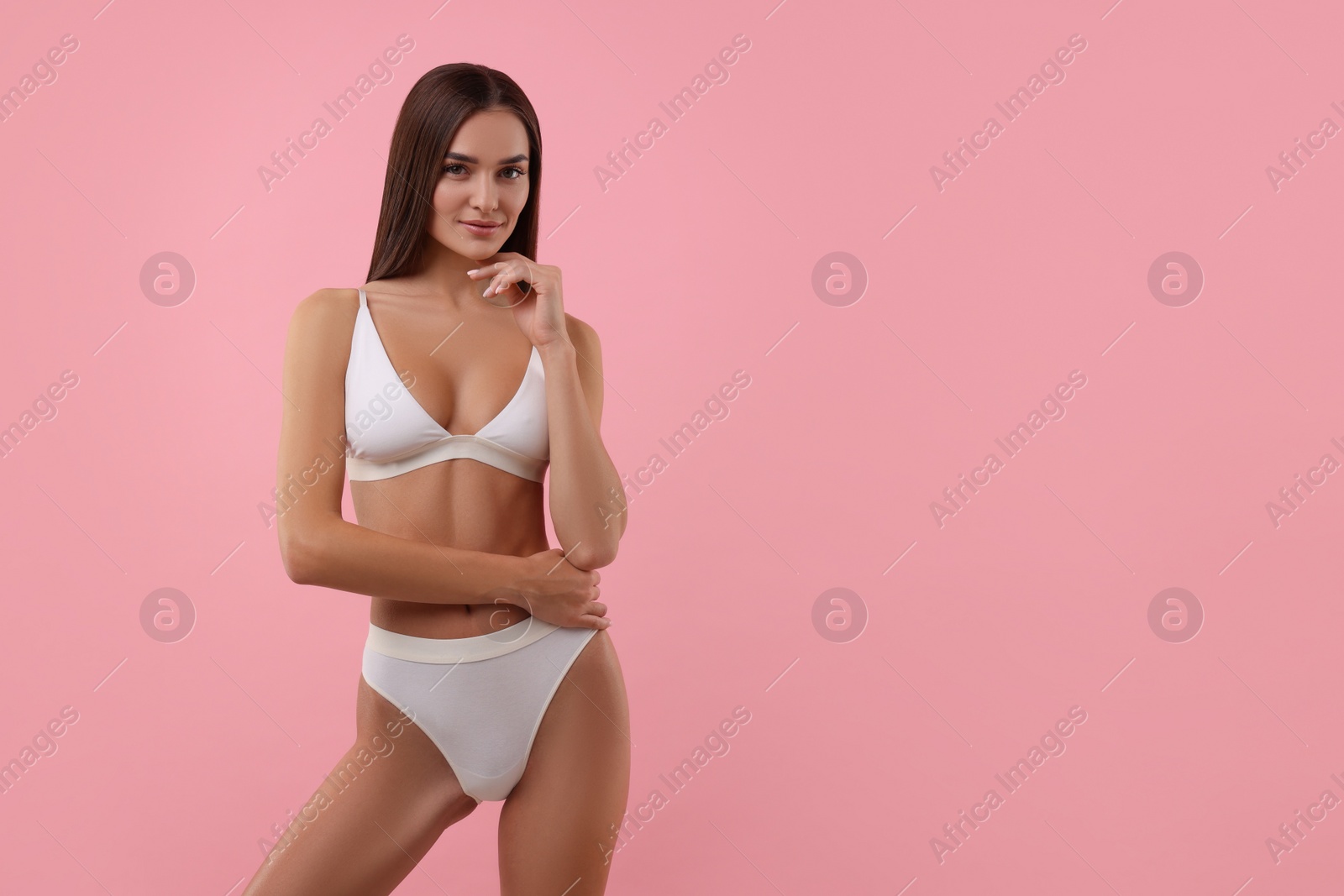 Photo of Young woman in stylish white bikini on pink background. Space for text