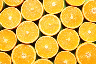 Halves of ripe oranges as background, top view