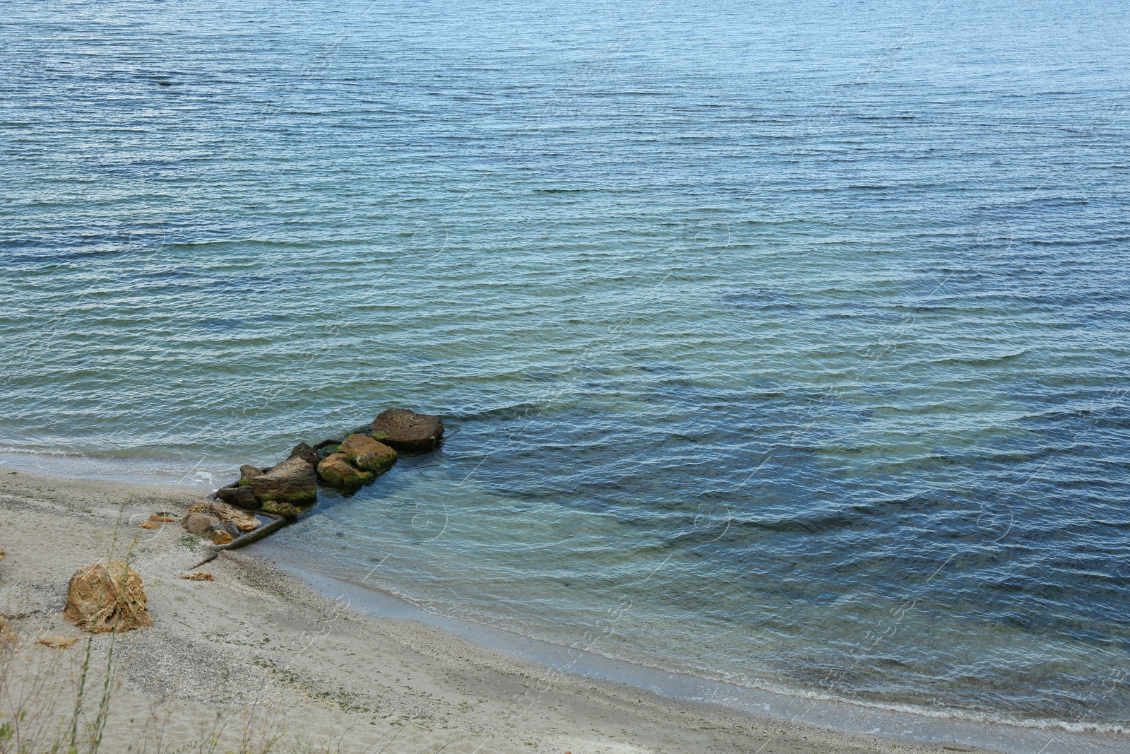 Photo of Picturesque view of sandy beach with stones and beautiful sea