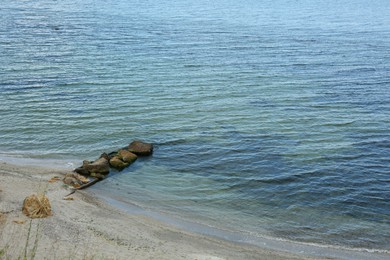 Photo of Picturesque view of sandy beach with stones and beautiful sea