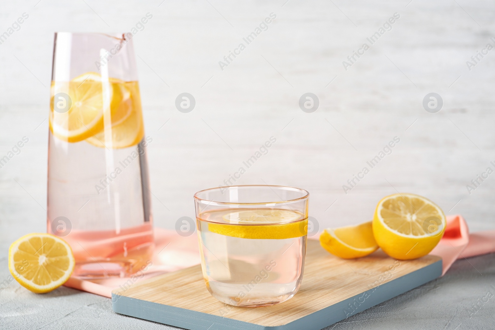 Photo of Glass of water with lemon slice on wooden board