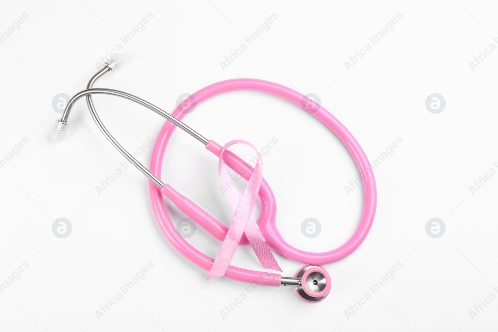 Photo of Pink ribbon and stethoscope on white background, top view. Breast cancer awareness