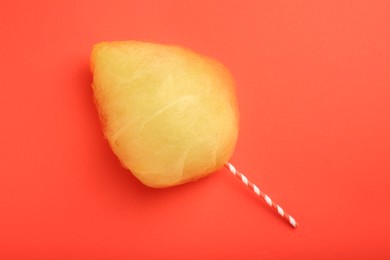 Photo of One sweet yellow cotton candy on red background, top view