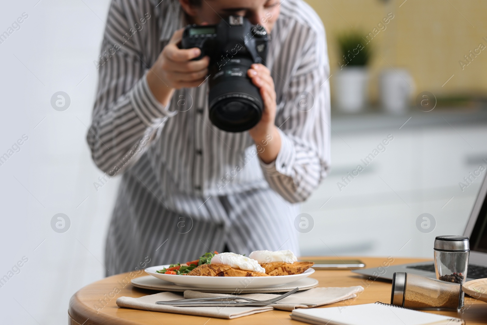 Photo of Food blogger taking photo of her lunch at table