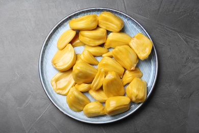 Photo of Delicious exotic jackfruit bulbs on grey table, top view