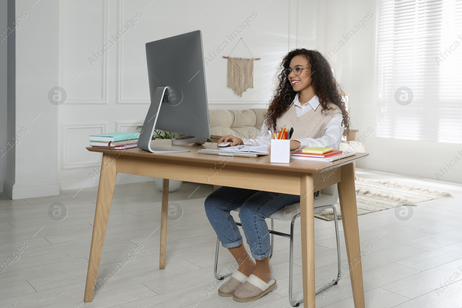 Photo of African American woman using modern computer for studying at home. Distance learning