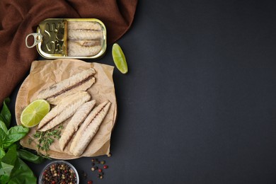 Photo of Canned mackerel fillets served on black table, flat lay. Space for text