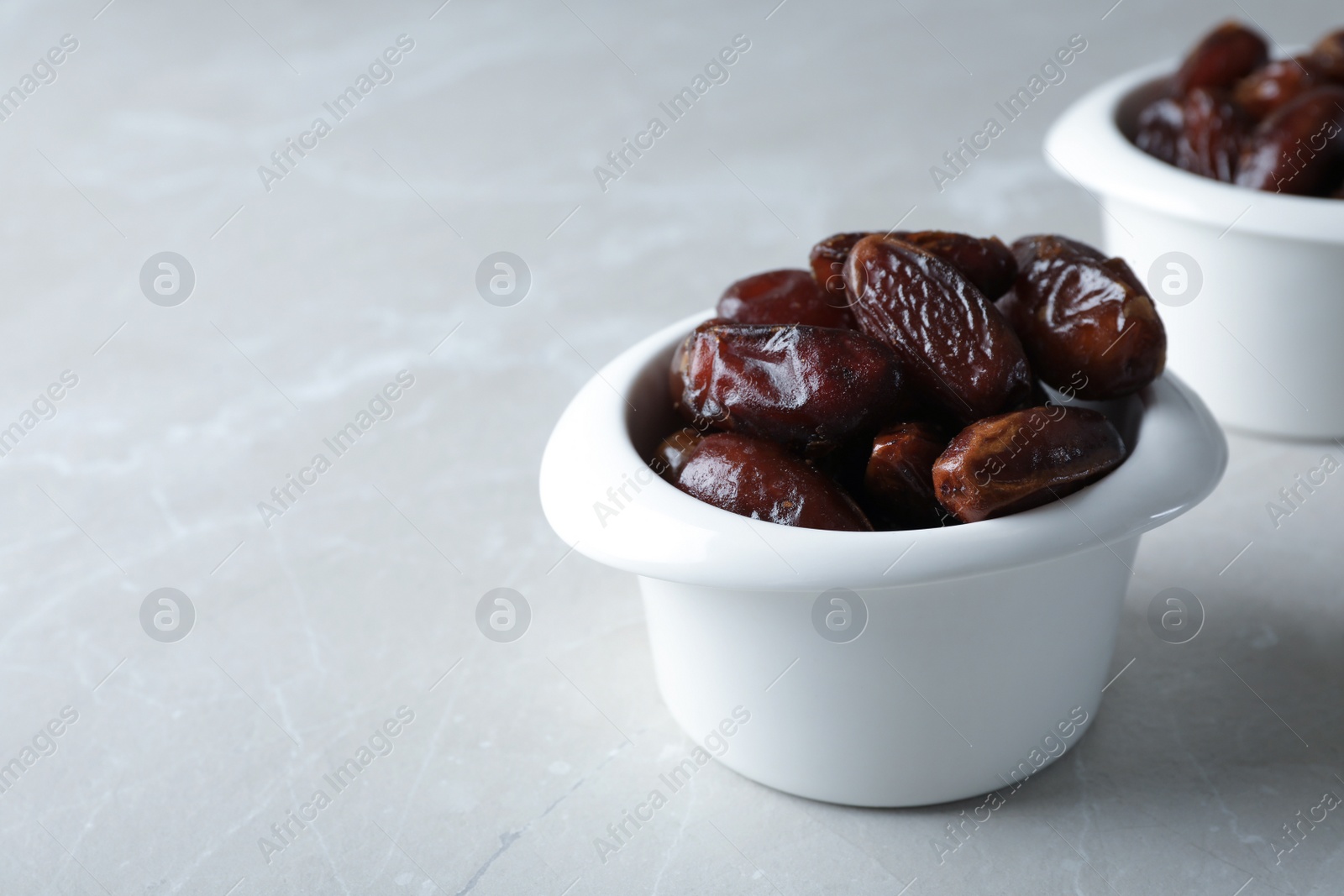 Photo of Bowl with sweet dates on table, space for text. Dried fruit as healthy snack