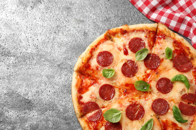Photo of Hot delicious pepperoni pizza on grey table, top view. Space for text