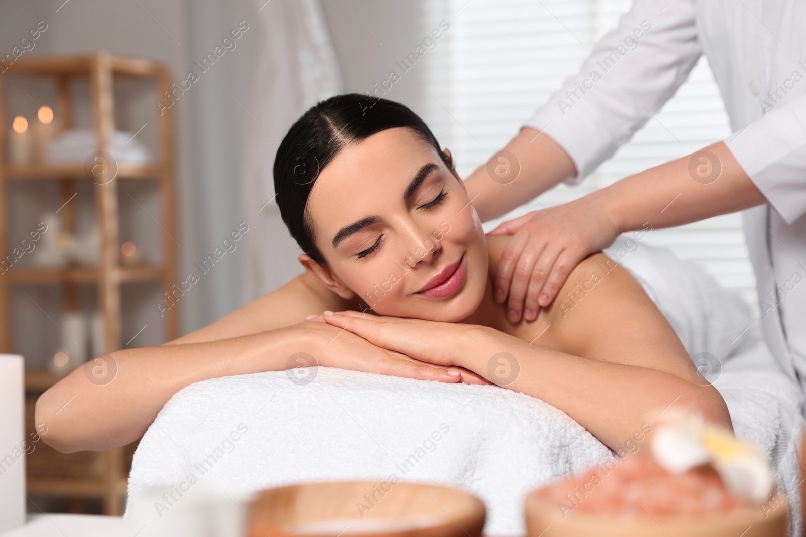 Photo of Beautiful woman receiving back massage in beauty salon, closeup