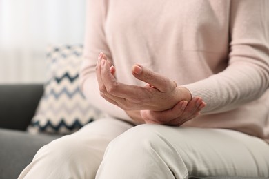 Photo of Arthritis symptoms. Woman suffering from pain in wrist at home, closeup